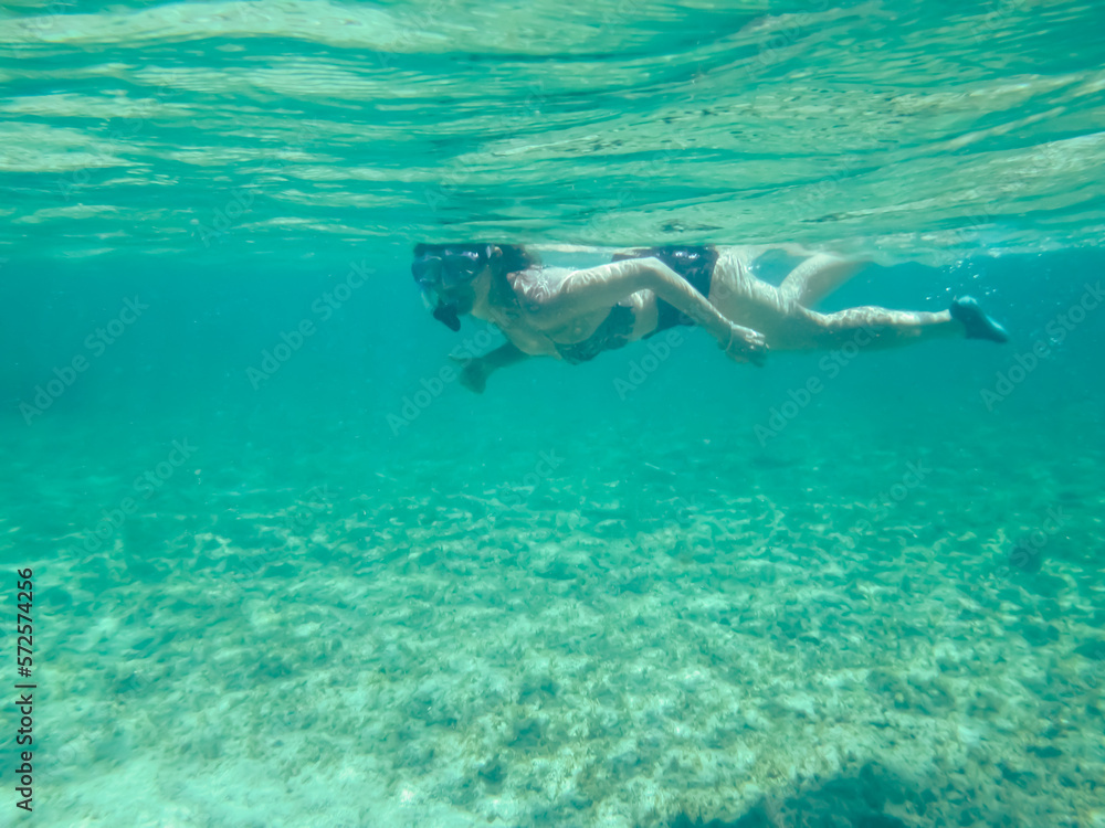 Chica joven practicando snorkel en aguas cristalinas. Fondo marino de la costa del mar Jónico, costa de Pizzo en Italia.