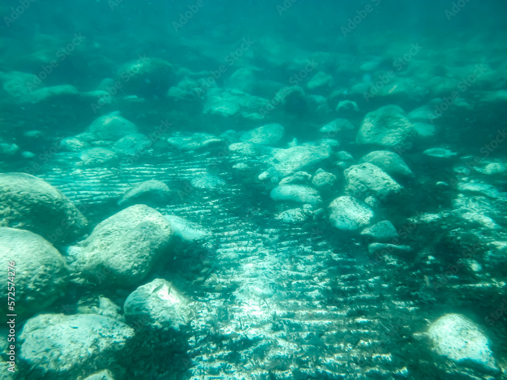 Obraz premium Fondo marino de arena con rocas y algas, fotografía submarina. Fondo marino de la costa del mar Jónico, costa de Pizzo en Italia.