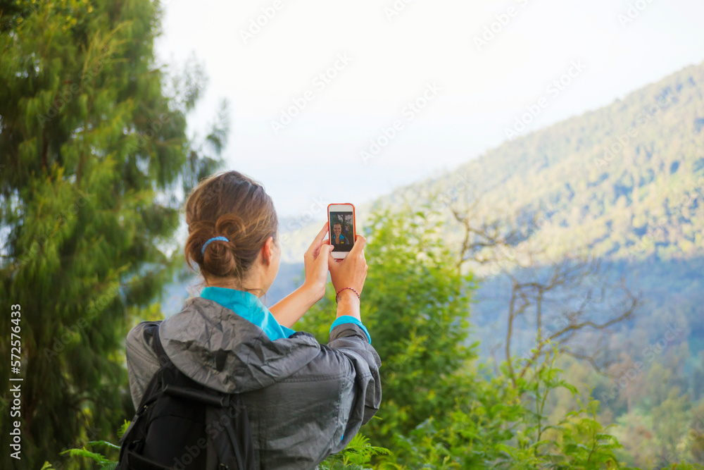Hiking woman taking photo with smart phone at mountain Hiking woman taking photo with smart phone at mountain