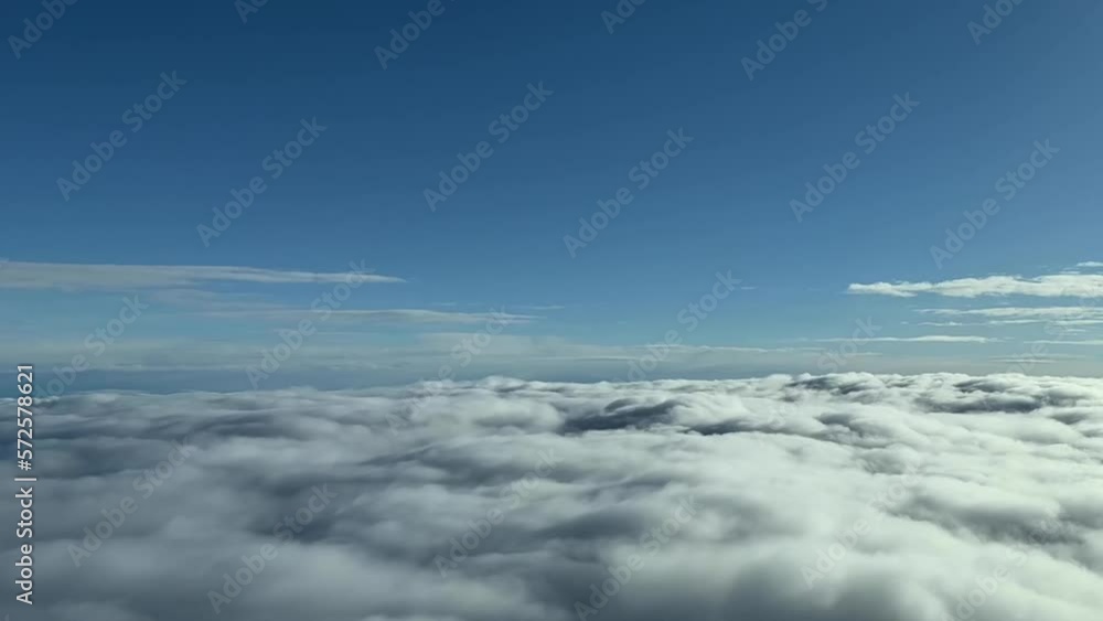 Aerial view from a jet cockpit while overflying a layer of stratus clouds during cruise level at 8000m high. Pilot point of view. Daylight. Aerial view from a jet cockpit while overflying a layer of stratus clouds during cruise level at 8000m high. Pilot point of view. Daylight.