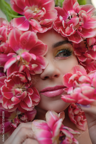 The face of beautiful woman with colorful make-up and flowers . The attractive woman lies in tulips. © Вероника Зеленина