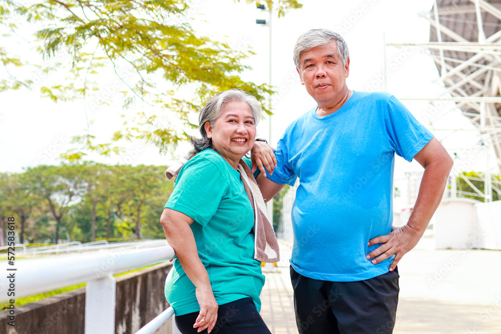 Asian elderly couple smiling happily after exercising outdoors together. Sports concept. health care in retirement
