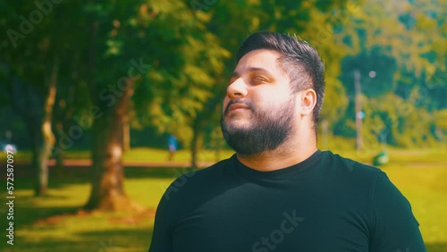 Orbital shot of a young man breathing outdoors at a parkl photo