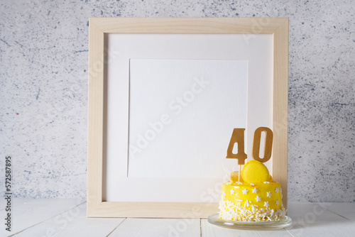 The number Forty on the yellow cake next to the white frame mockup with copy space.