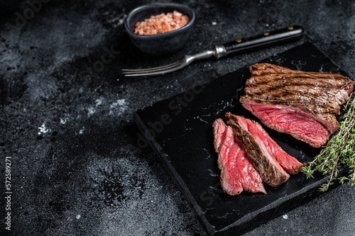 Grilled Wild Venison steak with thyme and salt, game meat. Black background. Top view. Copy space