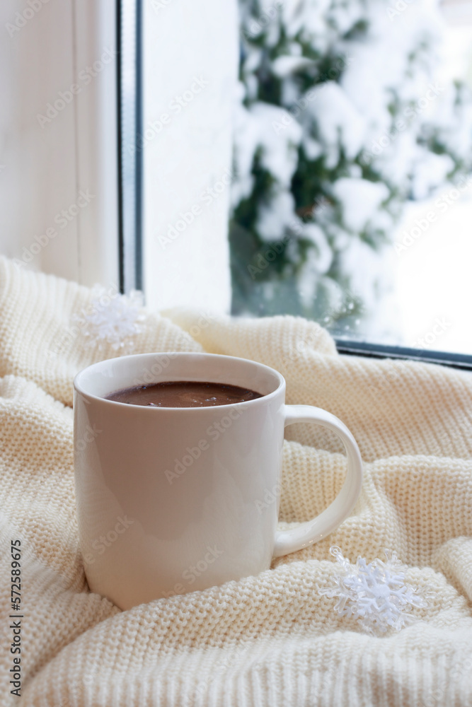 Cozy winter still life: a mug of hot coffee and a warm blanket. warming drink for a winter morning
