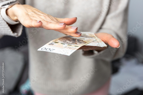Kobieta trzyma w dłoniach banknoty, pieniądze polskie, złotówki. Liczenie pieniędzy.
