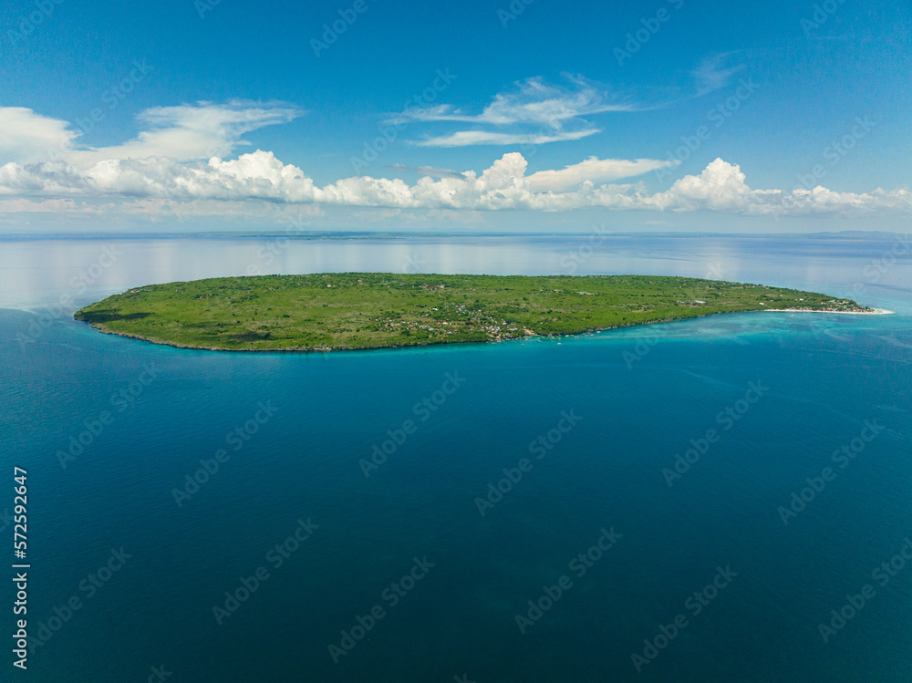 Tropical island against the blue sky and the ocean. Hilantagaan Island, Philippines.