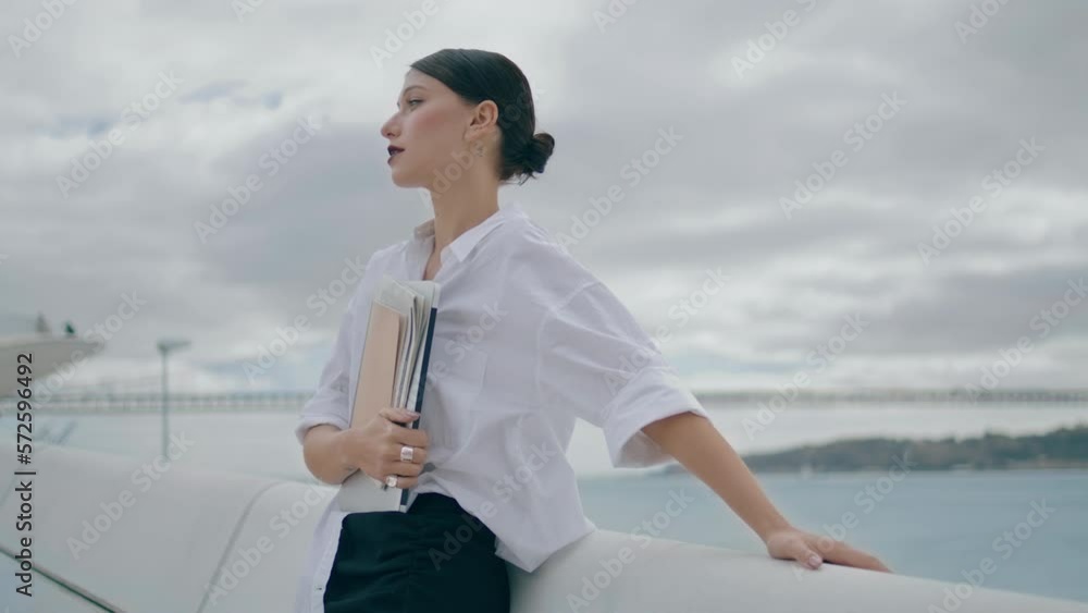 Businesswoman posing street documents cloudy day. Girl holding papers outdoors. Businesswoman posing street documents cloudy day. Girl holding papers outdoors.