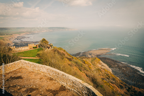 Ravenscar coast looking out to Robin Hoods Bay, North Yorkshire. Beautiful sky and sunset. Castle walls in the foreground.
