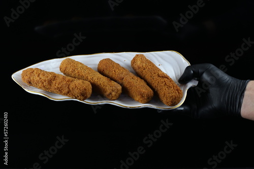 Hand Holding Fried Chicken Fingers Serving Plate - Isolated on Black Background