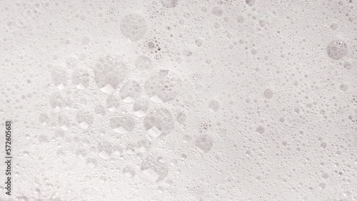 Texture of white soap foam with bubbles abstract background.