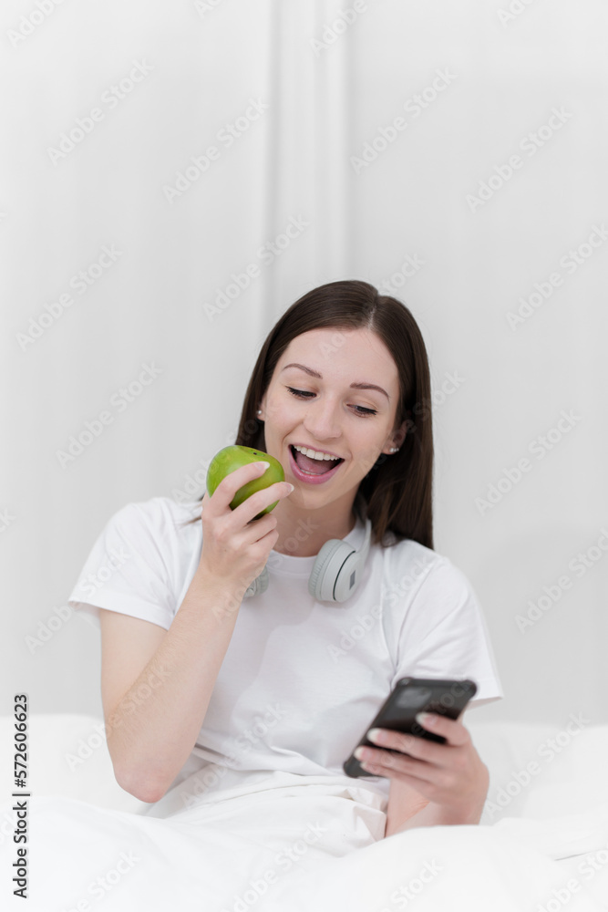 Portrait of Good Healthy woman eating green apple and resting in bed at bedroom. Lifestyle at home concept. Portrait of Good Healthy woman eating green apple and resting in bed at bedroom. Lifestyle at home concept.