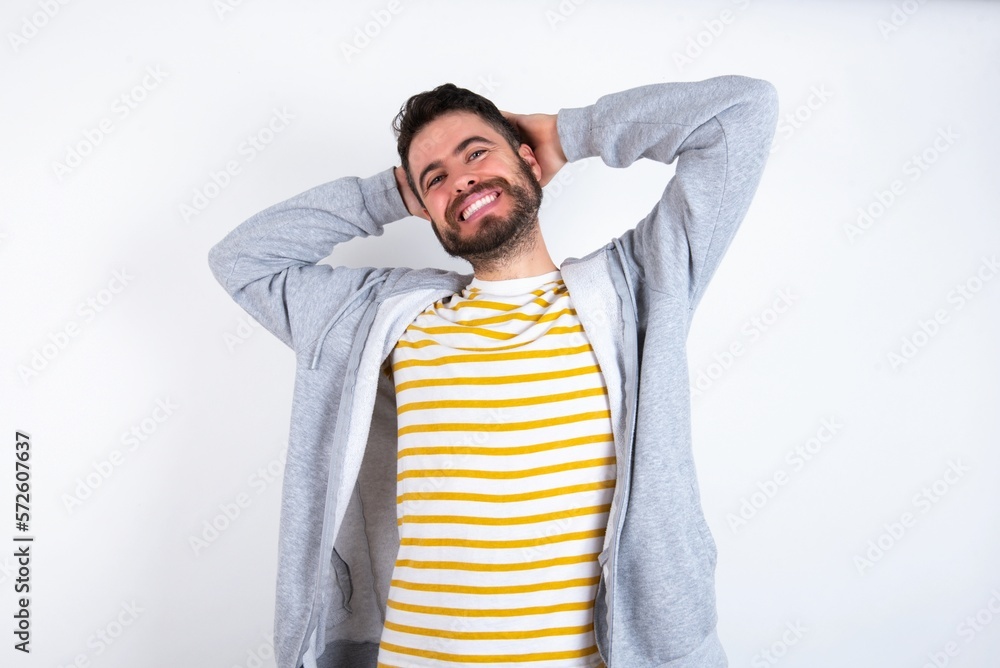 caucasian man wearing casual sportswear over white wall stretching arms, relaxed position. caucasian man wearing casual sportswear over white wall stretching arms, relaxed position.