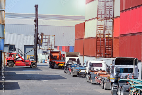 Forklifts, containers and trucks In the logistics yard with containers stacked in the background