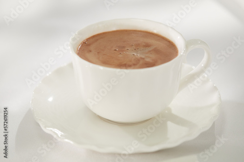 white cup of coffee on a light background. drink with coffee foam close-up.