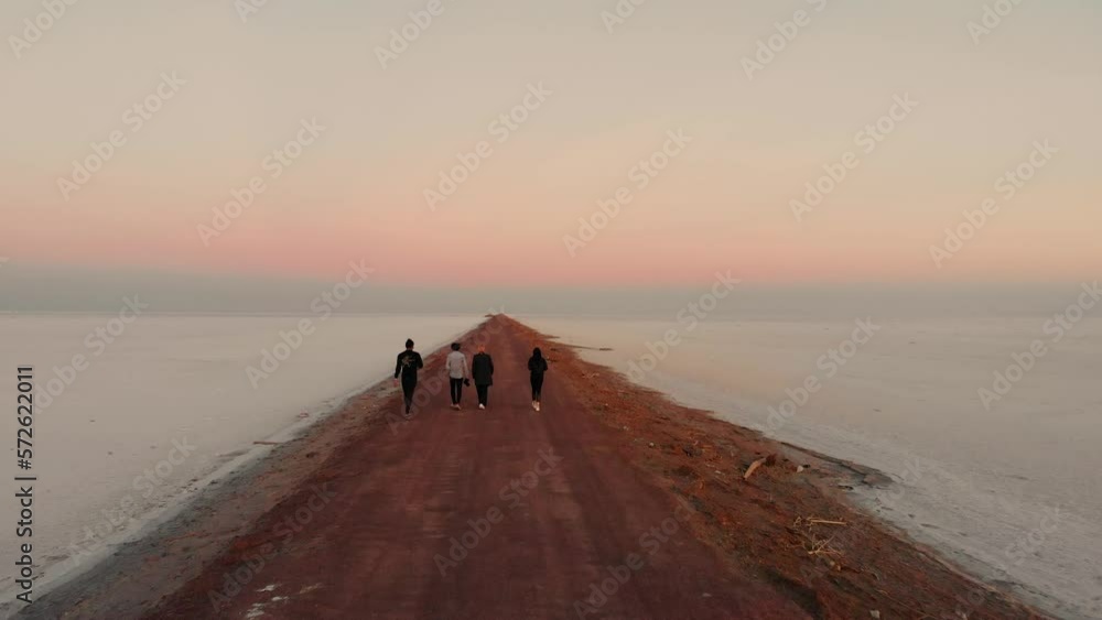 A group of friends walks down a road to infinity A group of friends walks down a road to infinity
