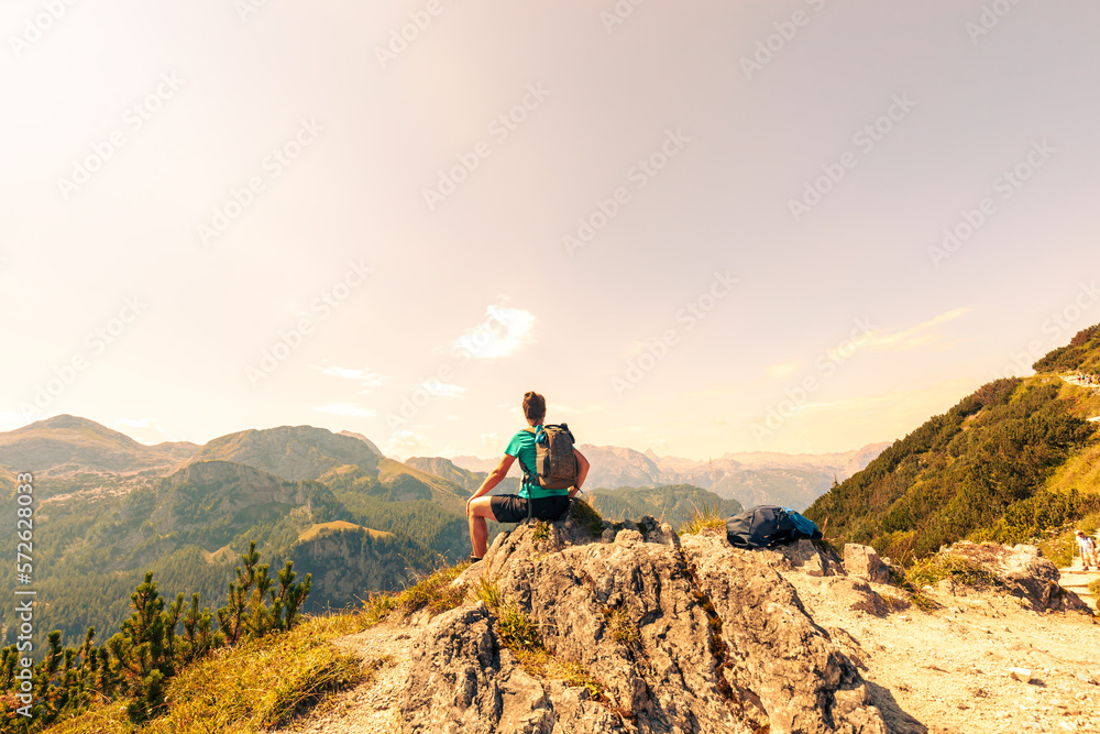 woman Hiking in the alps. Relaxing, resting on a Stone. Jenner Mountain - Berchtesgaden Alps, Germany, Bavaria, Schoenau am Königssee