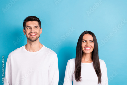Photo portrait of nice young guy girl look interested cheerful empty space dressed stylish white outfit isolated on blue color background