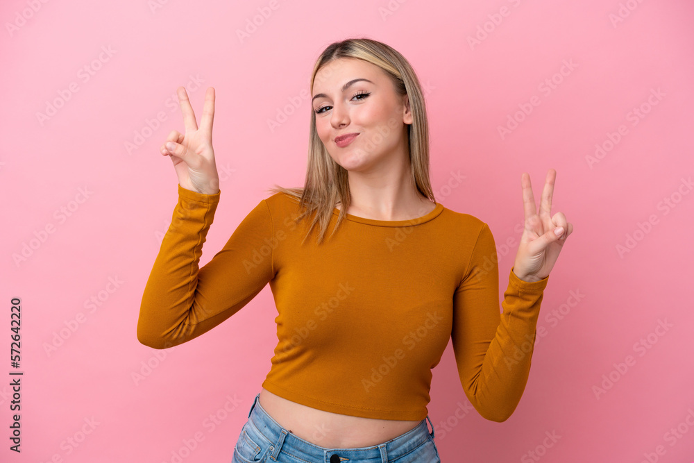 Young caucasian woman isolated on pink background showing victory sign with both hands Young caucasian woman isolated on pink background showing victory sign with both hands