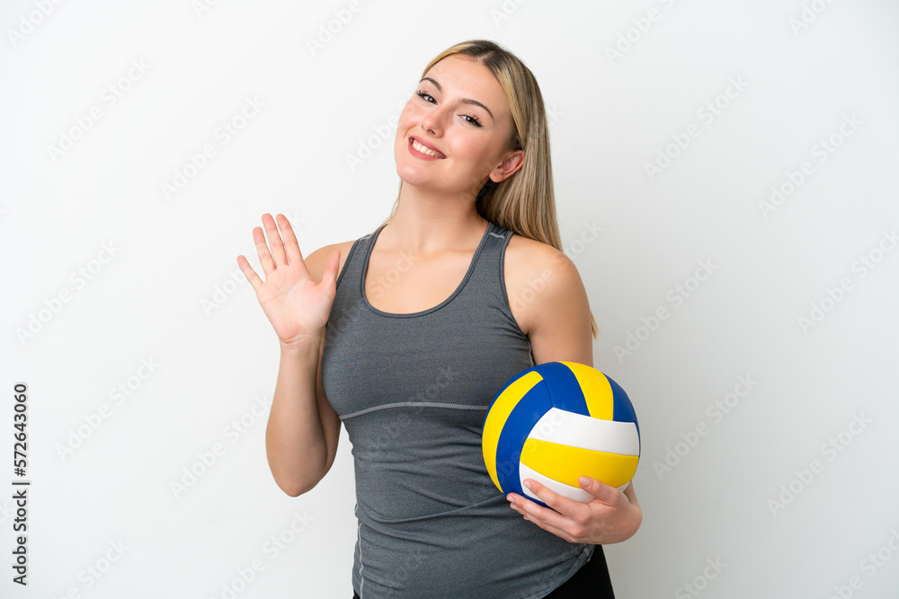 Young caucasian woman playing volleyball isolated on white background saluting with hand with happy expression
