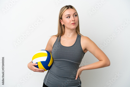 Young caucasian woman playing volleyball isolated on white background looking to the side