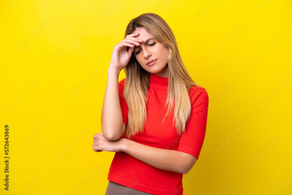 Young Uruguayan woman isolated on yellow background with headache Young Uruguayan woman isolated on yellow background with headache