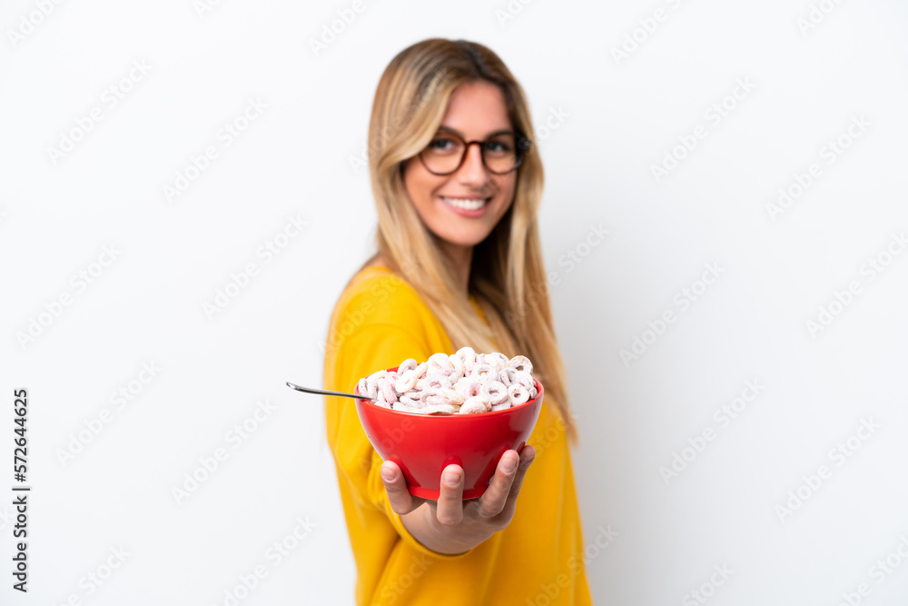 Young Uruguayan woman holding a bowl of cereals isolated on white background with happy expression Young Uruguayan woman holding a bowl of cereals isolated on white background with happy expression