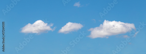 Blue clear sky, few clouds. Banner white cumulus clouds on a clear blue sky.