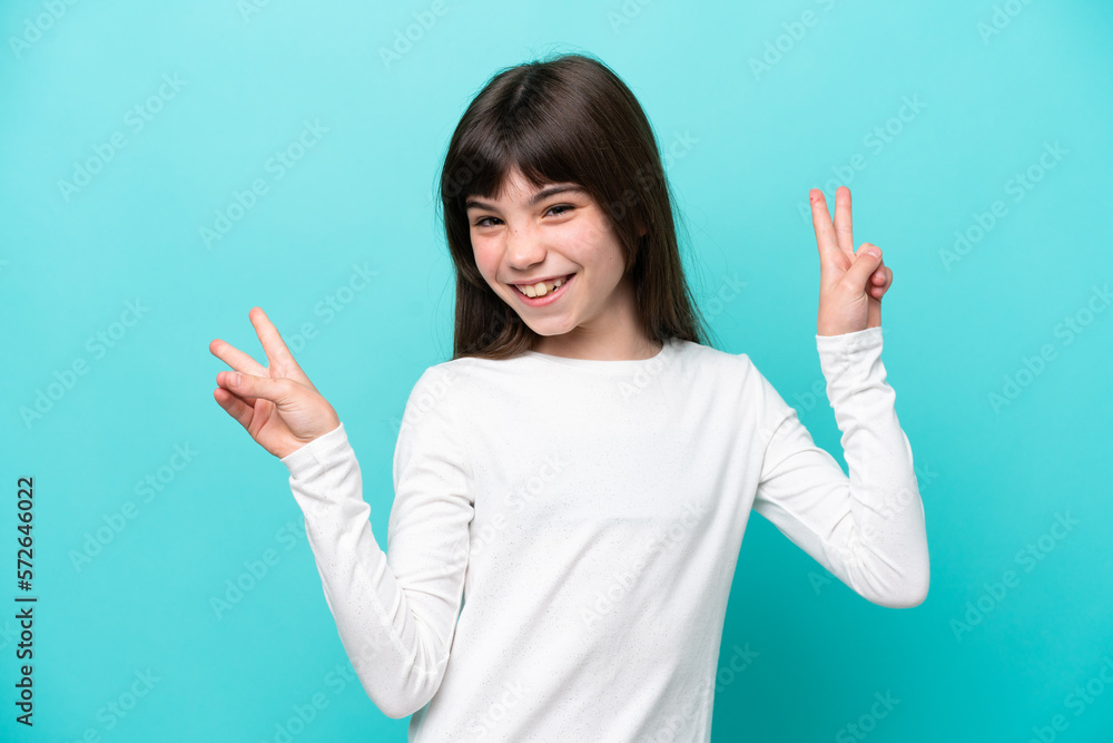 Little caucasian girl isolated on blue background showing victory sign with both hands Little caucasian girl isolated on blue background showing victory sign with both hands