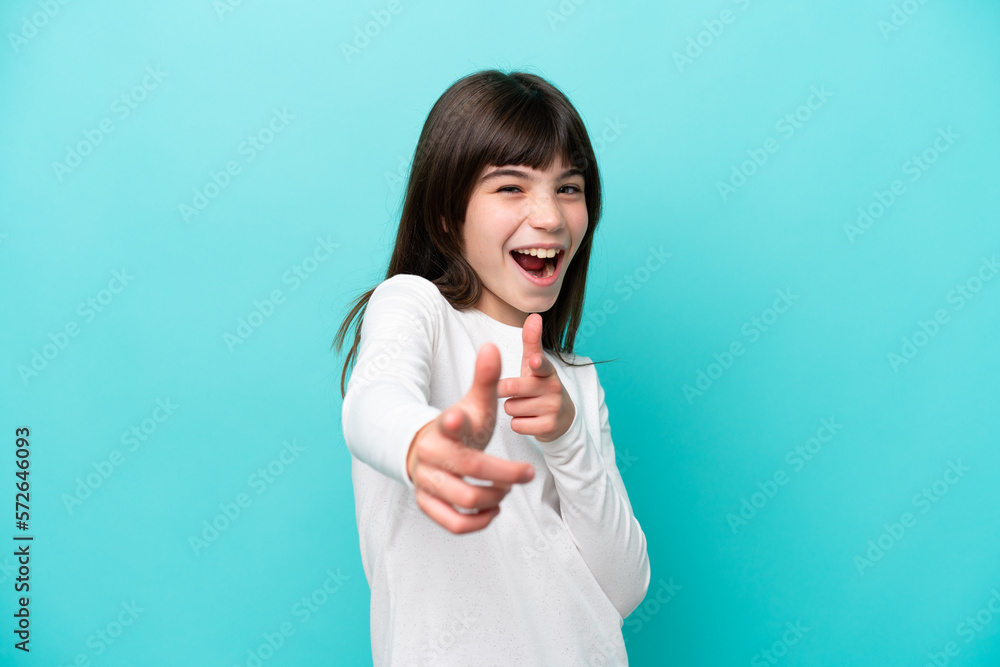 Little caucasian girl isolated on blue background pointing to the front and smiling Little caucasian girl isolated on blue background pointing to the front and smiling