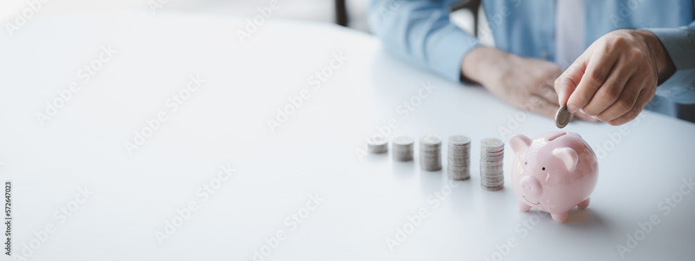 Person with pile of coins and piggy bank, money saving concept for future use and financial stability, salary management, personal finance, investment savings. - obrazy, fototapety, plakaty 