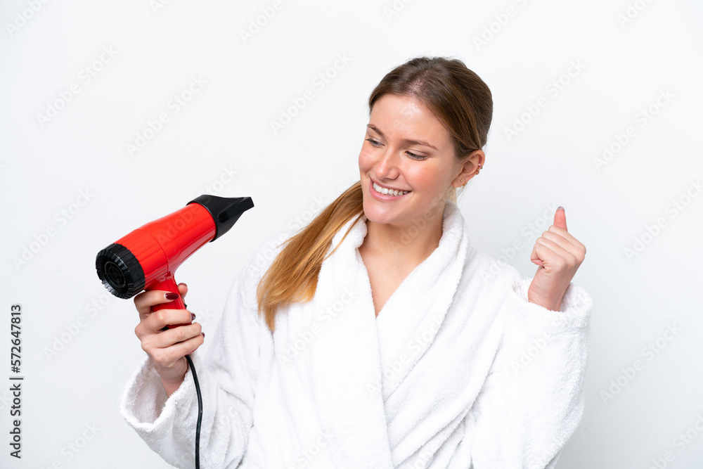 Young caucasian woman holding hairdryer isolated on white background celebrating a victory Young caucasian woman holding hairdryer isolated on white background celebrating a victory