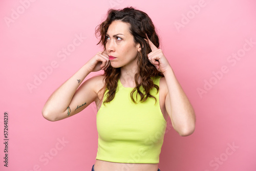 Young caucasian woman isolated on pink background having doubts and thinking