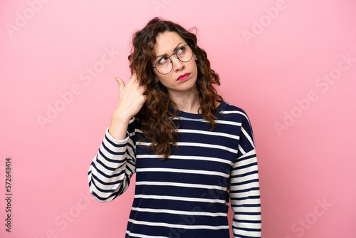 Young caucasian woman isolated on pink background with problems making suicide gesture