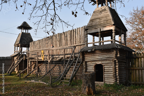 Wooden fortress wall against the sky. Medieval fortress with high walls. Wooden installation in the style of an ancient city. Stockade fence made of logs. Summer tourism and travel