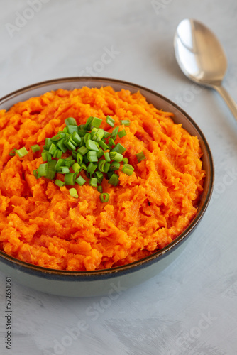 Homemade Creamy Mashed Sweet Potatoes with MIlk and Butter in a Bowl on a gray background, side view. Close-up.