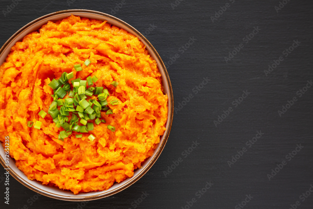 Homemade Creamy Mashed Sweet Potatoes with MIlk and Butter in a Bowl, top view. Copy space. Homemade Creamy Mashed Sweet Potatoes with MIlk and Butter in a Bowl, top view. Copy space.
