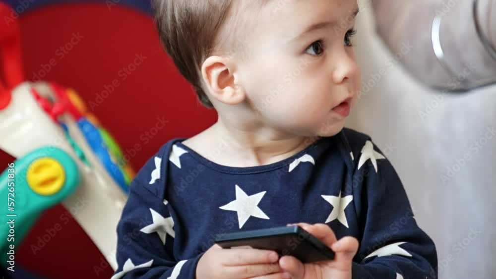Lovely kid in blue shirt with stars plays with his toys. Adorable baby focused on the bright toys around him. Close up. Lovely kid in blue shirt with stars plays with his toys. Adorable baby focused on the bright toys around him. Close up.
