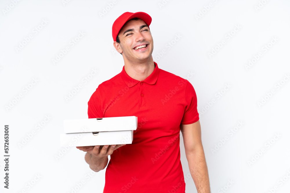 Pizza delivery caucasian man with work uniform picking up pizza boxes isolated on white background laughing Pizza delivery caucasian man with work uniform picking up pizza boxes isolated on white background laughing