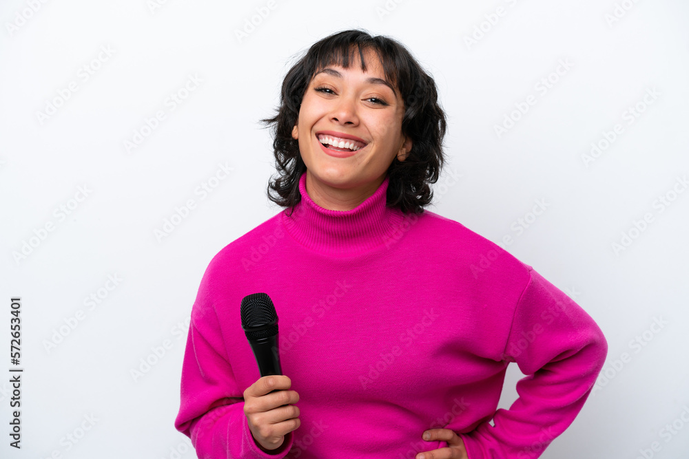 Young Argentinian singer woman isolated on white background posing with arms at hip and smiling Young Argentinian singer woman isolated on white background posing with arms at hip and smiling