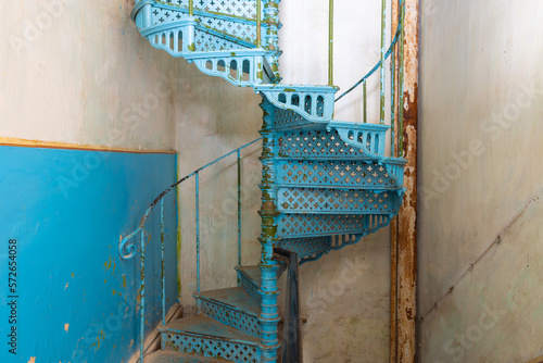 Old shabby blue metal spiral staircase in the interior of the Sharovsky castle, Ukraine