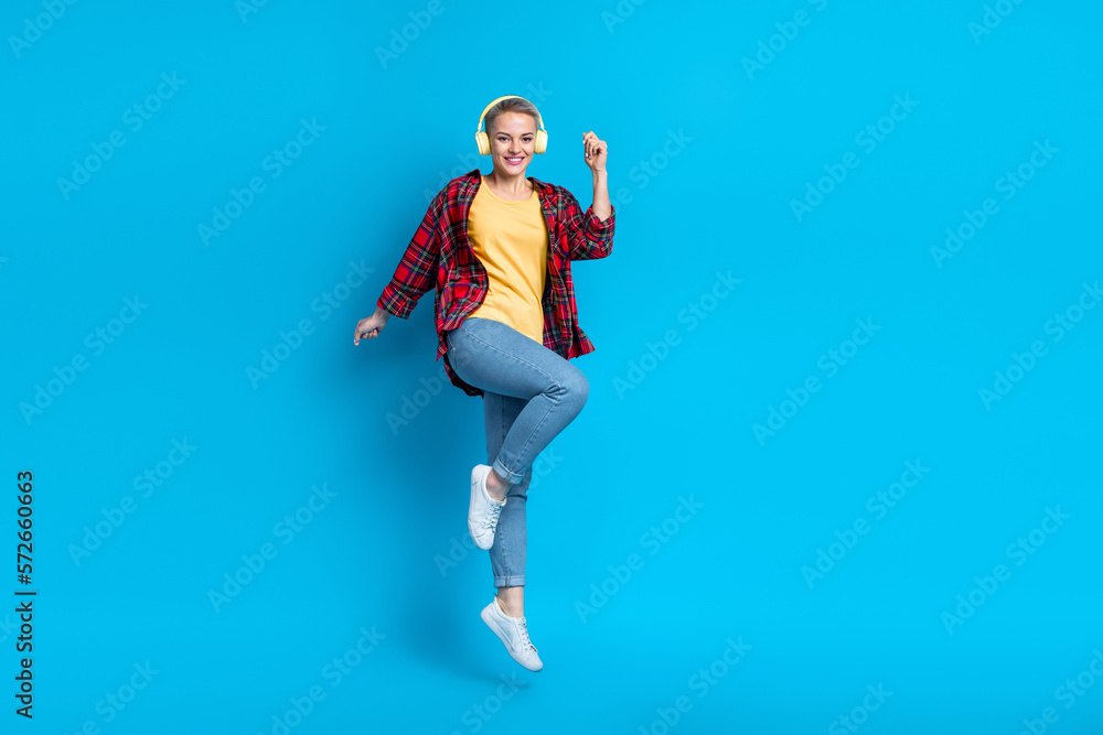 Full size photo of satisfied carefree girl with short hairstyle wear red shirt flying dancing having fun isolated on blue color background Full size photo of satisfied carefree girl with short hairstyle wear red shirt flying dancing having fun isolated on blue color background