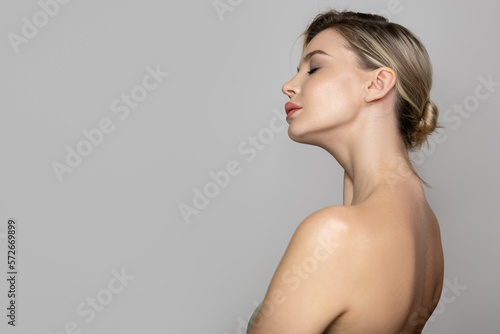 Tableau sur toile Young beautiful woman stands on her side with bare shoulders and back
