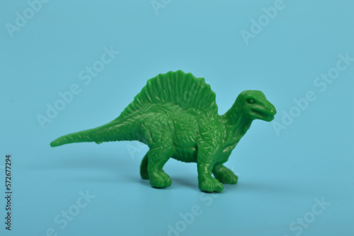 Toy spinosaurus dinosaurs isolated on a blue background © TeacherPhoto