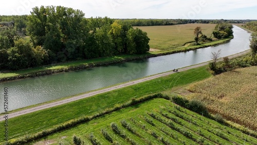 Foto People riding bikes on tow path trail beside Erie Canal through rural countrysid