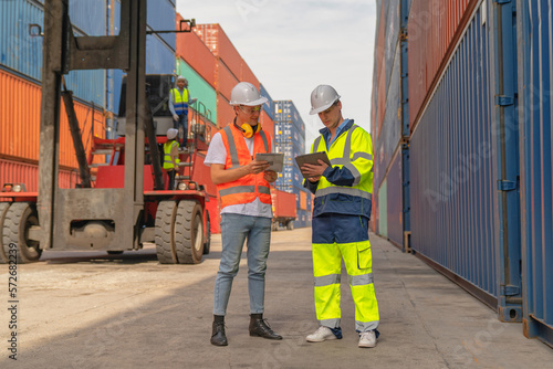 Engineers are overseeing the transportation of cargo with containers inside the warehouse. Container in export and import business and logistics.