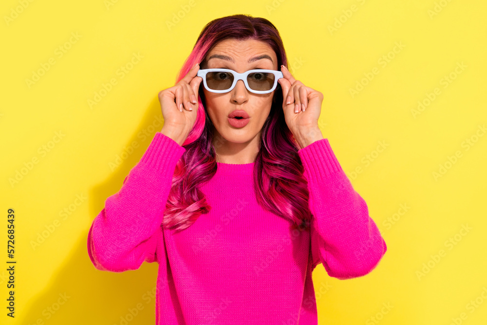 Portrait of shocked confused girl pouted lips arms touch 3d glasses isolated on yellow color background Portrait of shocked confused girl pouted lips arms touch 3d glasses isolated on yellow color background