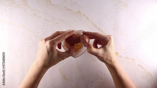 Breaking and mixing breaks chicken eggs into a bowl.