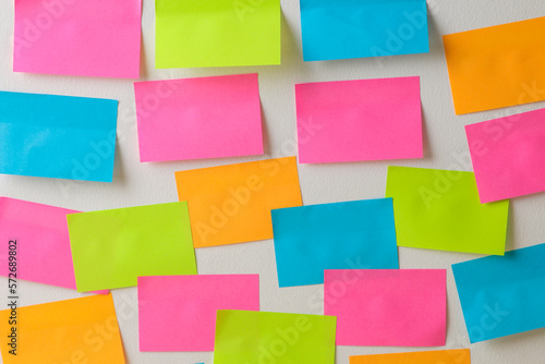 Multicolored various notes or sticky post-it on a white wall